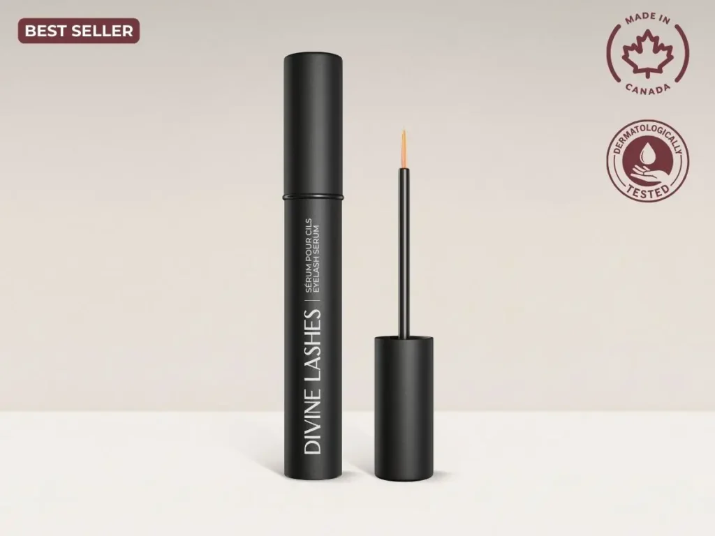 A clean, minimalist studio shot of the black Divine Lashes serum tube and its fine-point applicator brush against a neutral light grey background.